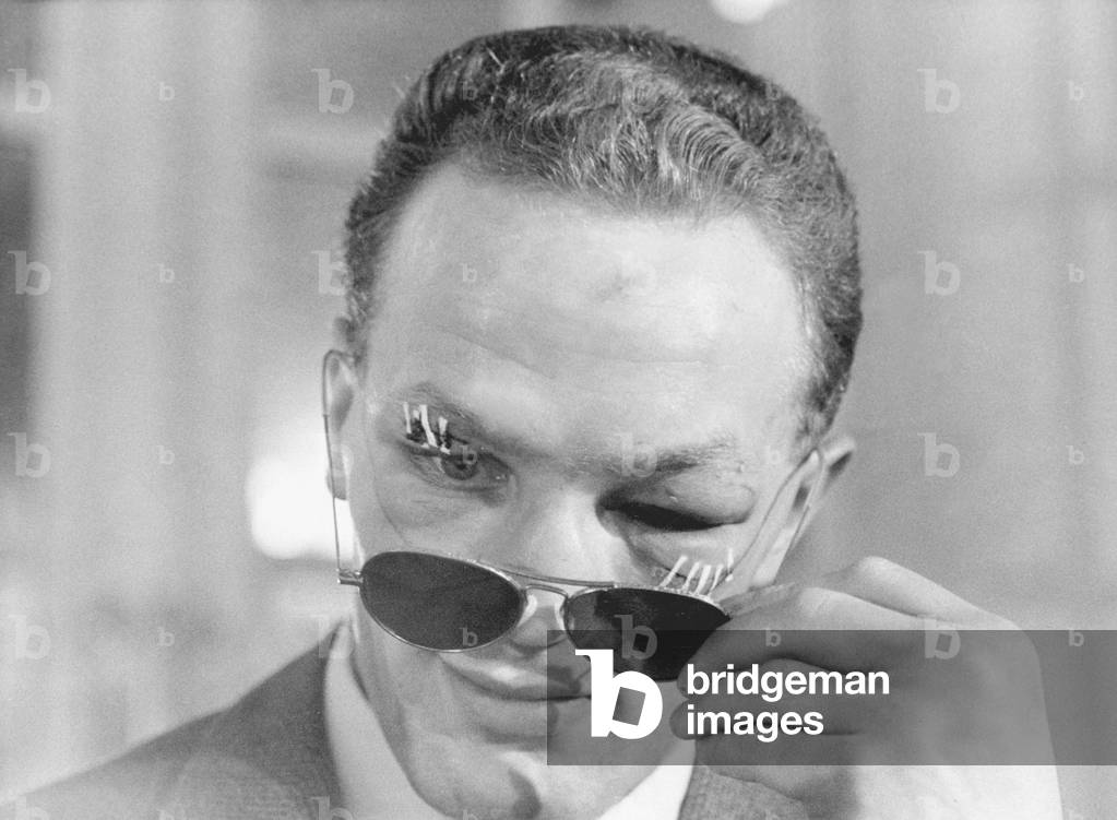 Henry Cooper, the new British and Empire Heavyweight boxing champion looks from behind dark glasses at the annual Variety Club of Great Britain sports celebrities lunch at the Savoy. Cooper had defeated Brian London to gain the title. January 13th 1959 (b/w photo)