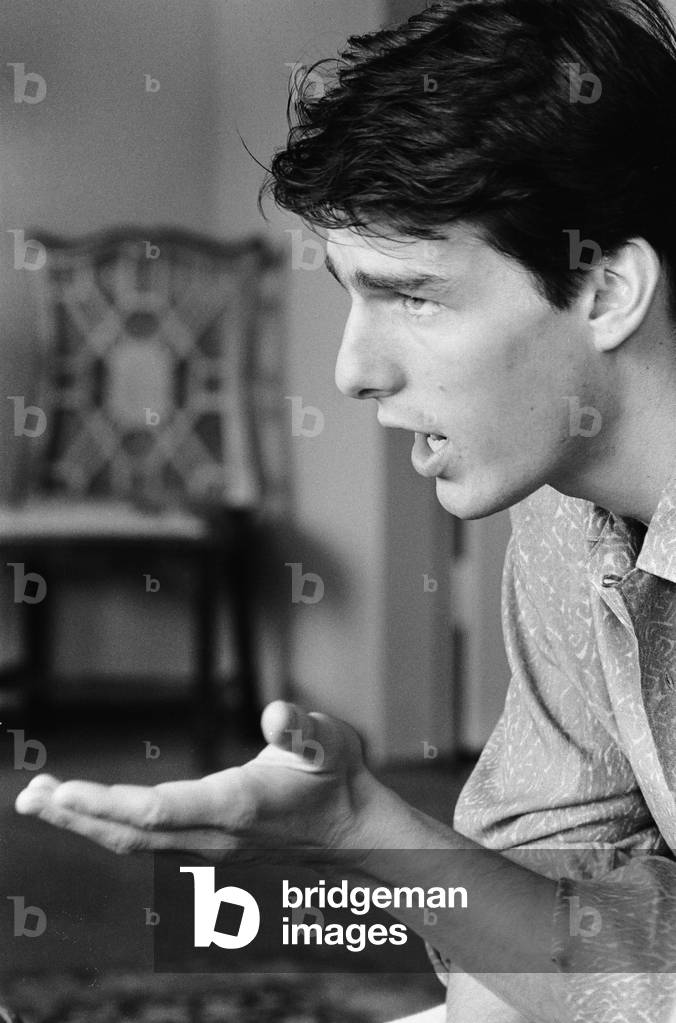 American actor Tom Cruise answers questions during an interview in his hotel suite on a visit to London, after the release of his latest film Top Gun in the United States, 26th June 1986 (b/w photo)