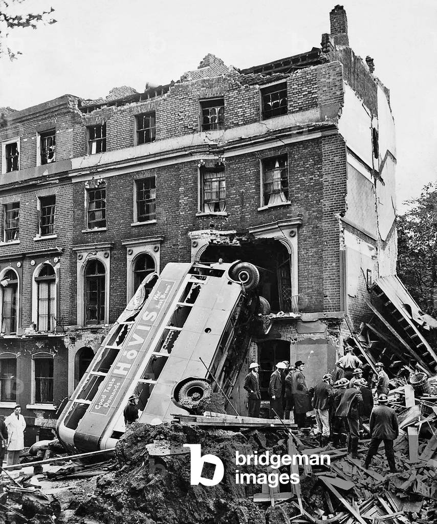 A London double decker bus hit by the blast from a bomb dropped during an air raid leaning against number 34 Harrington Square Garden North London. The driver and passengers took cover in a shelter when the raid began unfortunately ten of the local residents in numbers 35 and 36 were killed 9th September 1940 (b/w photo)