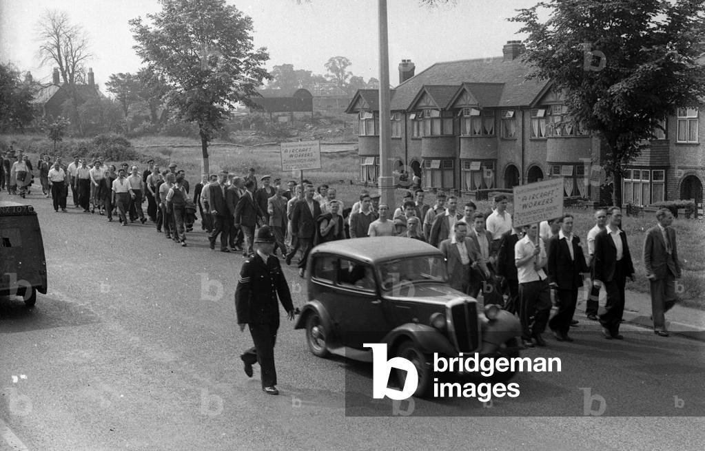 Coventry aerospace workers march and demonstrate following the announcement from Defence Secretary Duncan Sands that the aircraft industry should re-organise, several smaller companies becoming a few larger ones. It was made clear that new military contracts would only be given to aerospace companies that had merged. March 1957 (b/w photo)