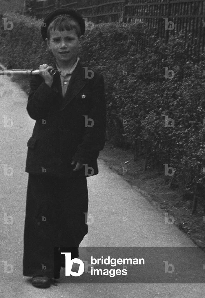 Small boy seen here walking through the streets of Moscow carrying their daily catch of fish from the Moskva River. 25th May 1960 (b/w photo)