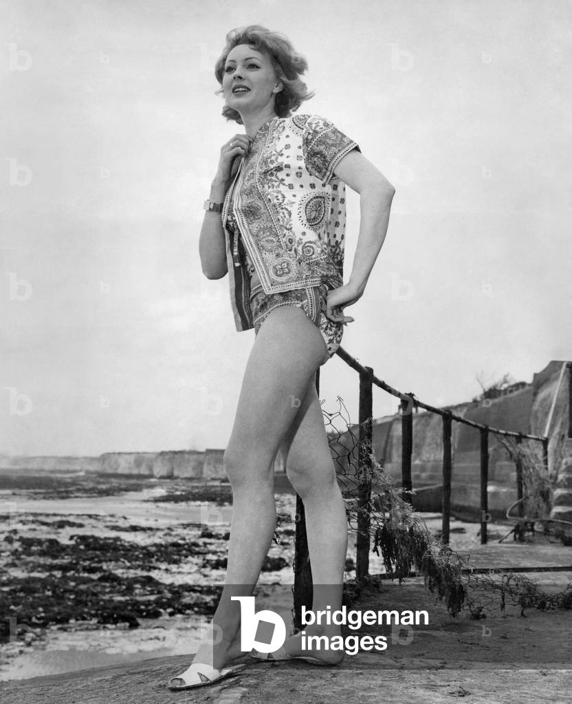 Clothing Beach: An ideal three-piece that is catching on quick for the really hot spots. A tiny bikini with a handkerchief print lawn tunic. You can get it in four colours, at the eye-catching price of 27s. 6d. April 1961 P017991