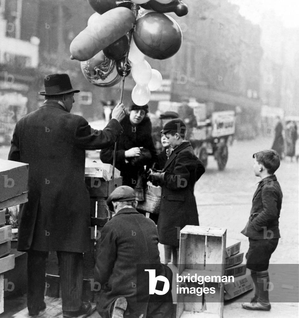 The balloon man was doing a roaring trade in the centre of Newcastle on 21st December 1936 (b/w photo)