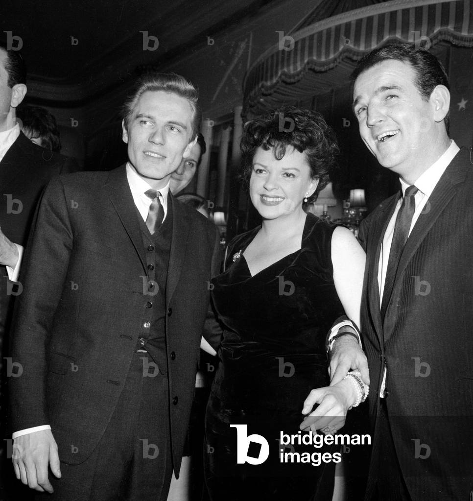 Film actress Judy Garland with pop singer Adam Faith (left) and Radio DJ Alan Freeman (right) at a film party for Judy Garland at a London hotel
May 1962