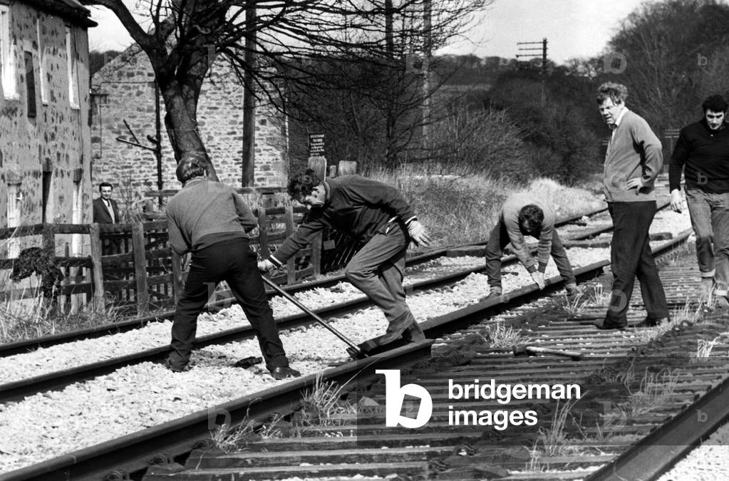 A recovery gang from Worksop taking up the stretch of line outside the historic cottage in Wylam where George Stephenson, father of the railway, was born, on 6th April 1972 (b/w photo)