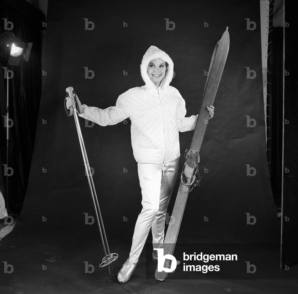 Clothing: Fashion: Woman wearing skiing outfit converted from wedding dress, 1963 (b/w photo)