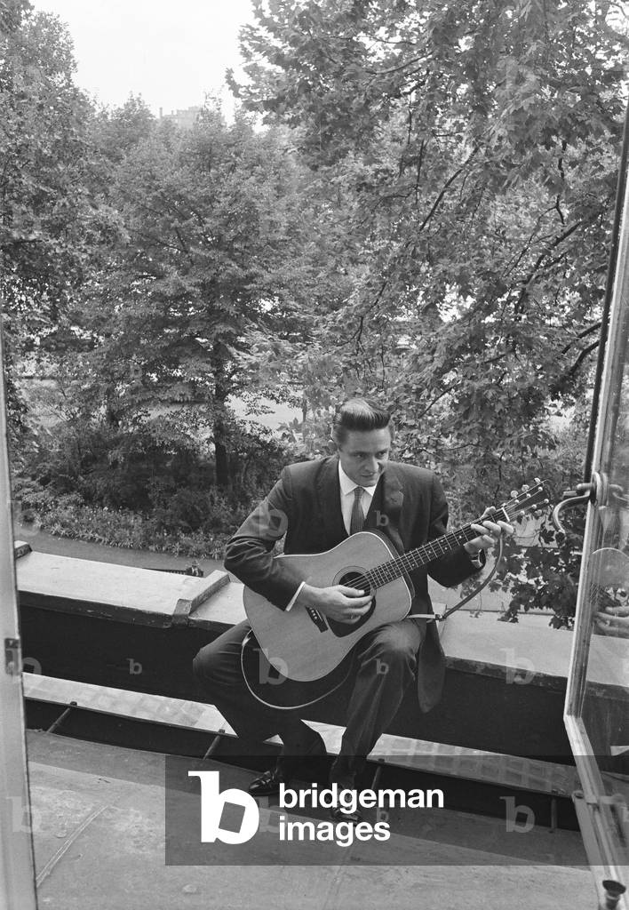 American country singer and musician Johnny Cash poses for photographers at the Savoy Hotel in London. 17th September 1959 (b/w photo)