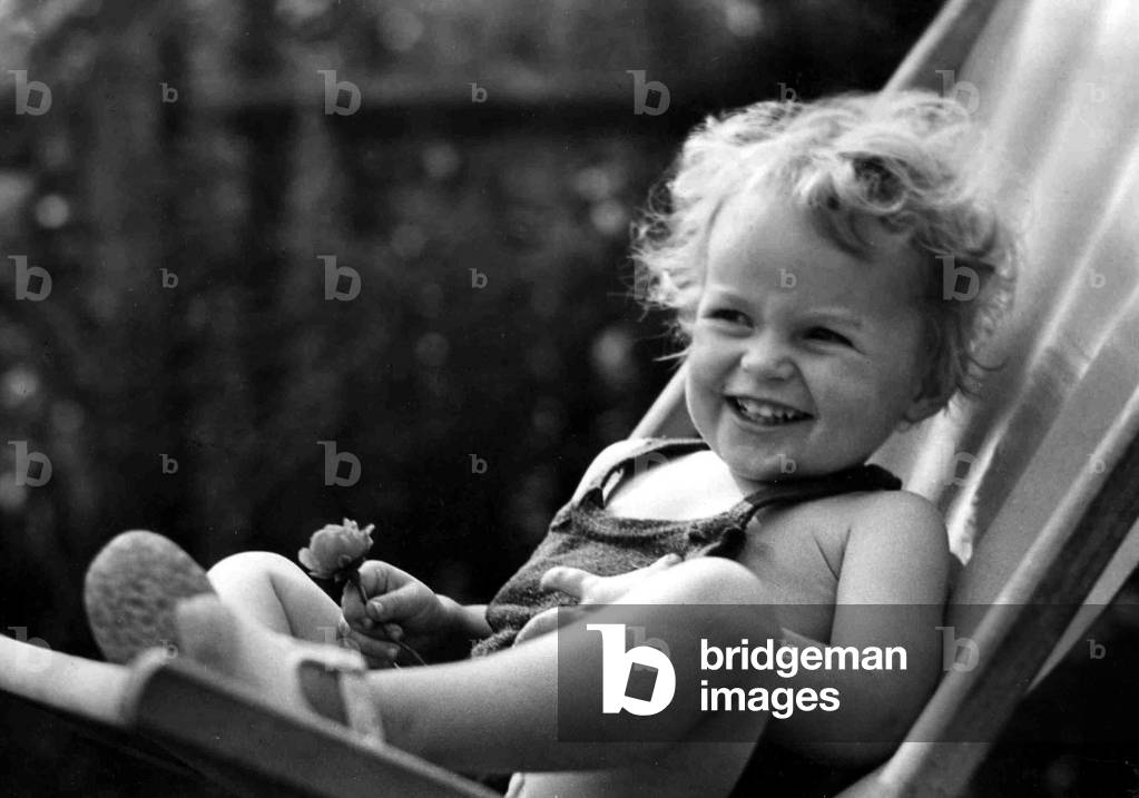 Young girl relaxing on a deck chair in her back garden
Circa 1945