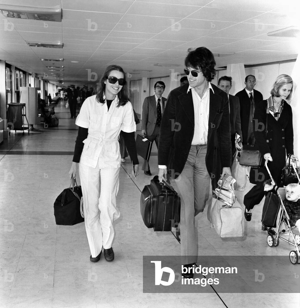 American actor Warren Beatty at Heathrow Airport with Michelle Phillips, May 1975 (b/w photo)