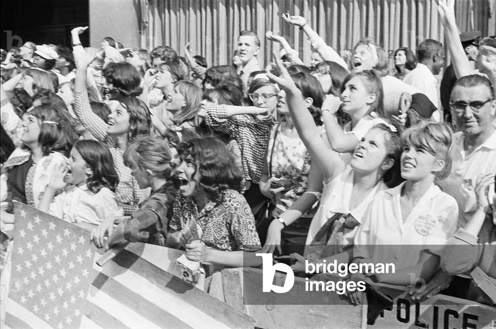 The Beatles in New York City, on their North American Tour ahead of their concert to be held at Forest Hills. Cheering fans gathered outside the Delmonico Hotel in New York where the band are staying. 28th August 1964 (b/w photo)