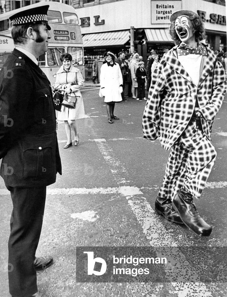 A policeman having a joke with a clown at the opening of the Newcastle Festival Parade in 1974