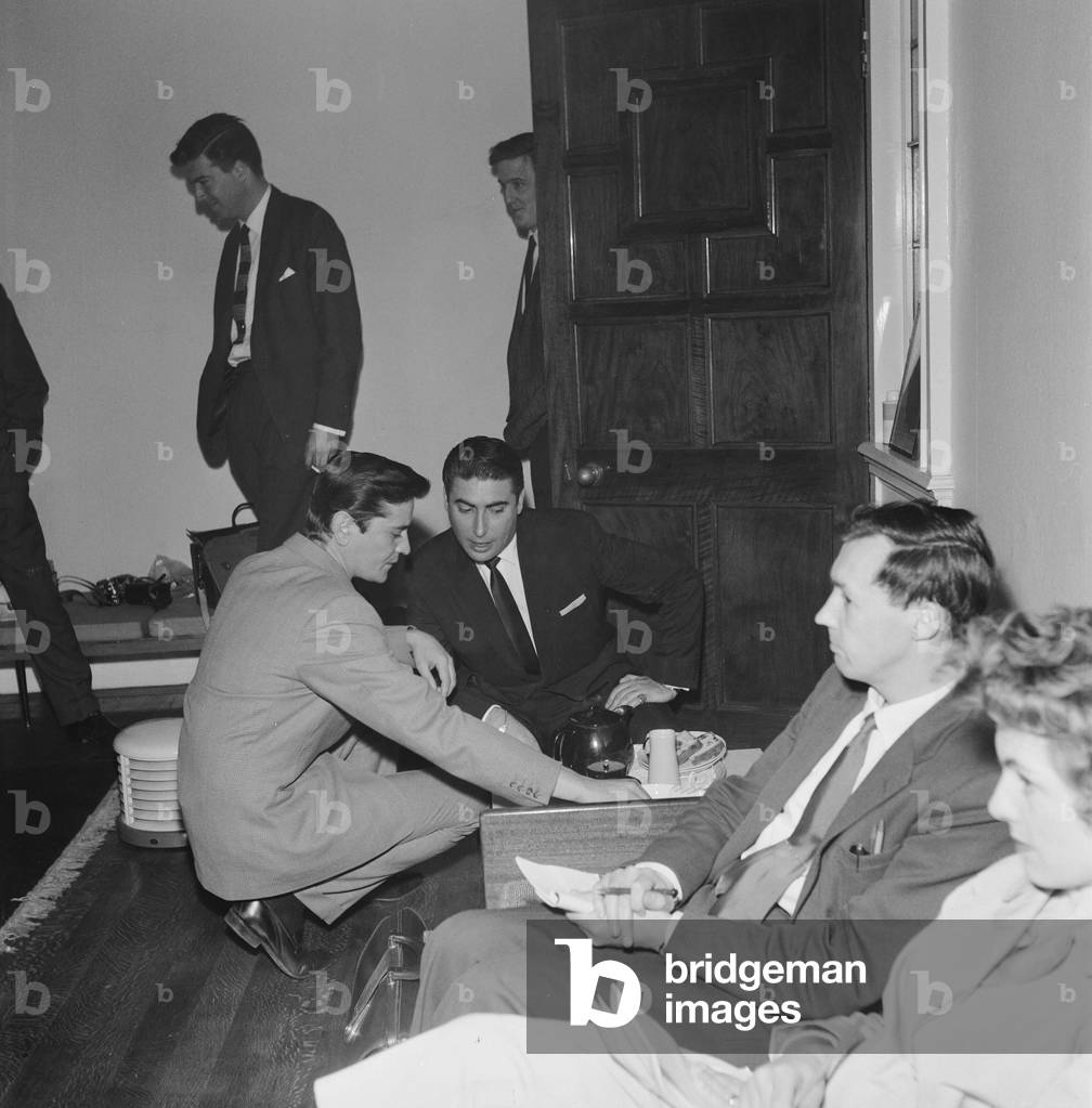 Larry Parnes (centre) and John Kennedy (left), Managers of singer Tommy Steele, crouch down as they enjoy a pot of tea, 28th April 1961 (b/w photo)