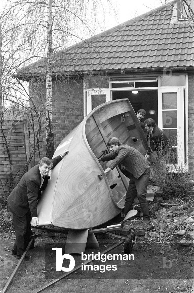 Mr Henry Fowler (left) enlists the aid of some friends to help him to take the boat out of his living room where it was built 27th March 1970 (b/w photo)