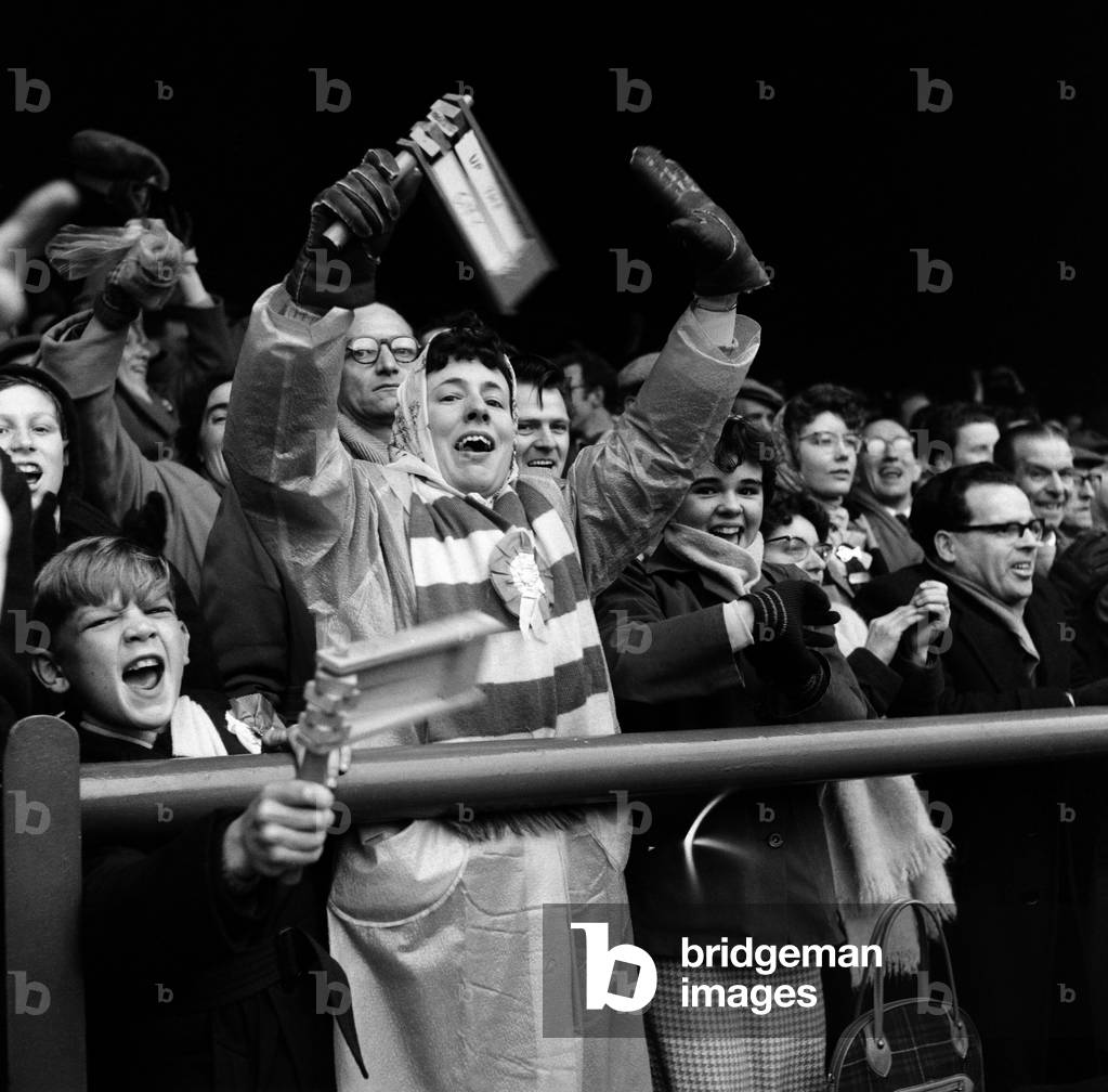 FA Cup Quarter Final match at Filbert Street. Leicester City 1 v Wolverhampton Wanderers 2. Excited Leicester supporters at the match, with one woman holding her rattle. 12th March 1960 (photo)