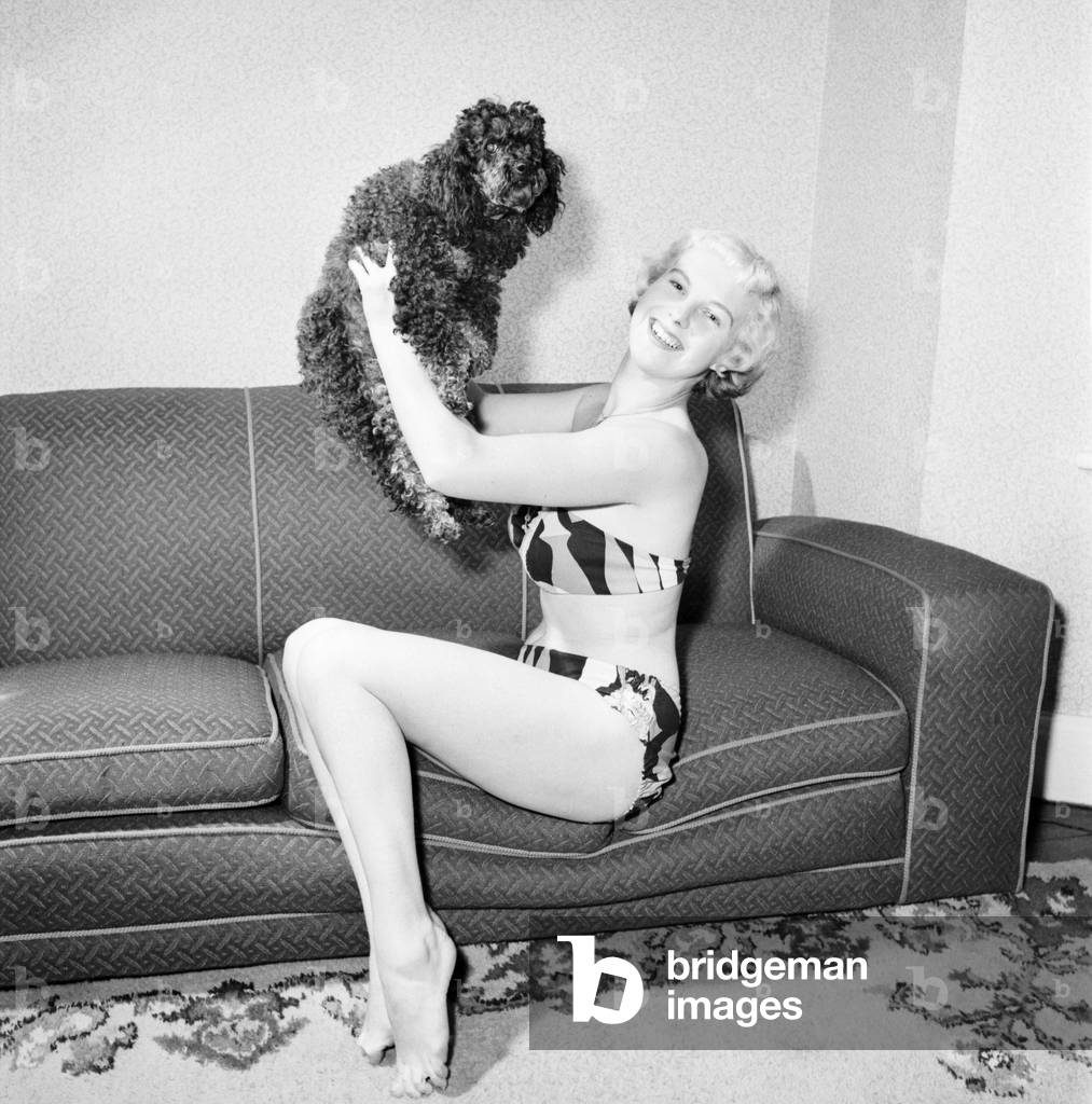 Pat Bolton seen here with her pet poodle dog, 1964 (b/w photo)