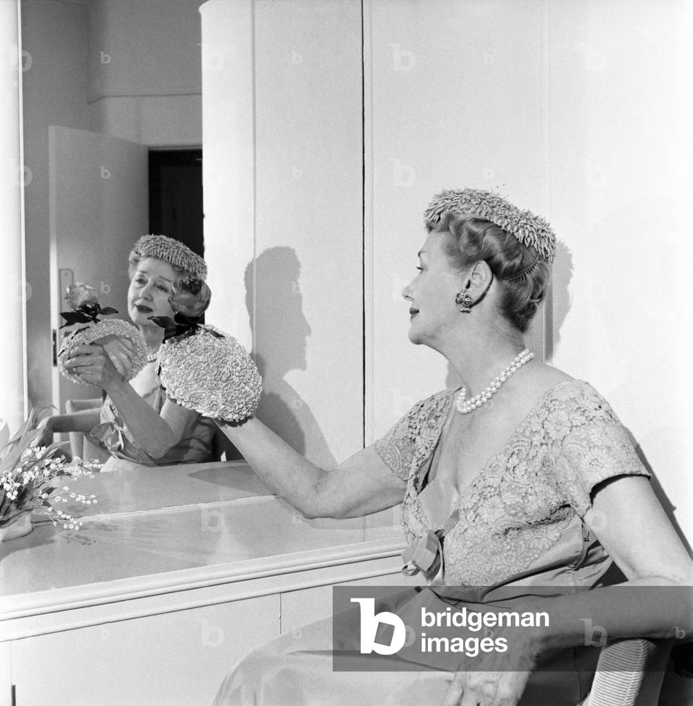 Hedda Hopper who is going to present to the Queen two of her fantastic hats. June 1953 D2958-002