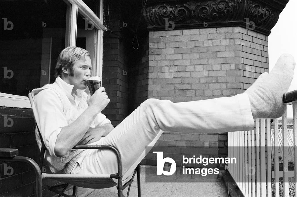 Australian tour of Great Britain for the Ashes. First test match at Old Trafford between England and Australia. The Daddy Long Legs of the England side Tony Greig takes a well earned glass of beer after the match was over. 13th June 1972 (b/w photo)