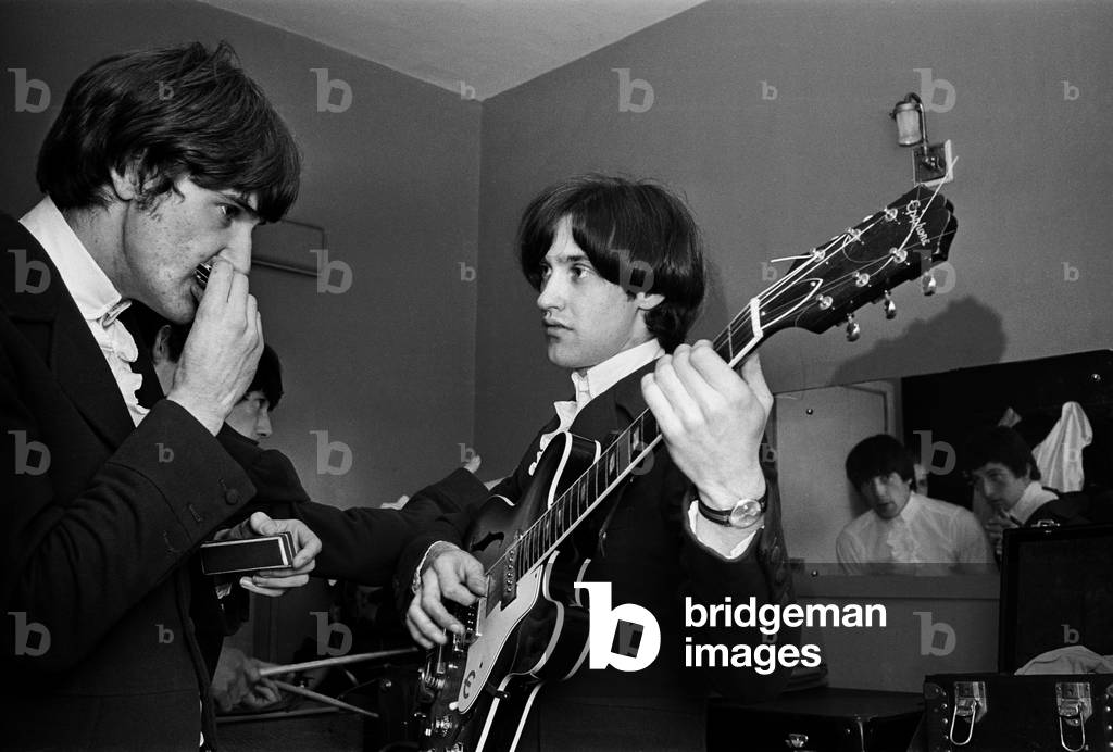 Ray Davies and Dave Davies of The Kinks pop group rehearsing in their dressing room before a concert
September1964