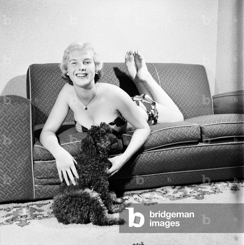 Pat Bolton seen here with her pet poodle dog, 1964 (b/w photo)