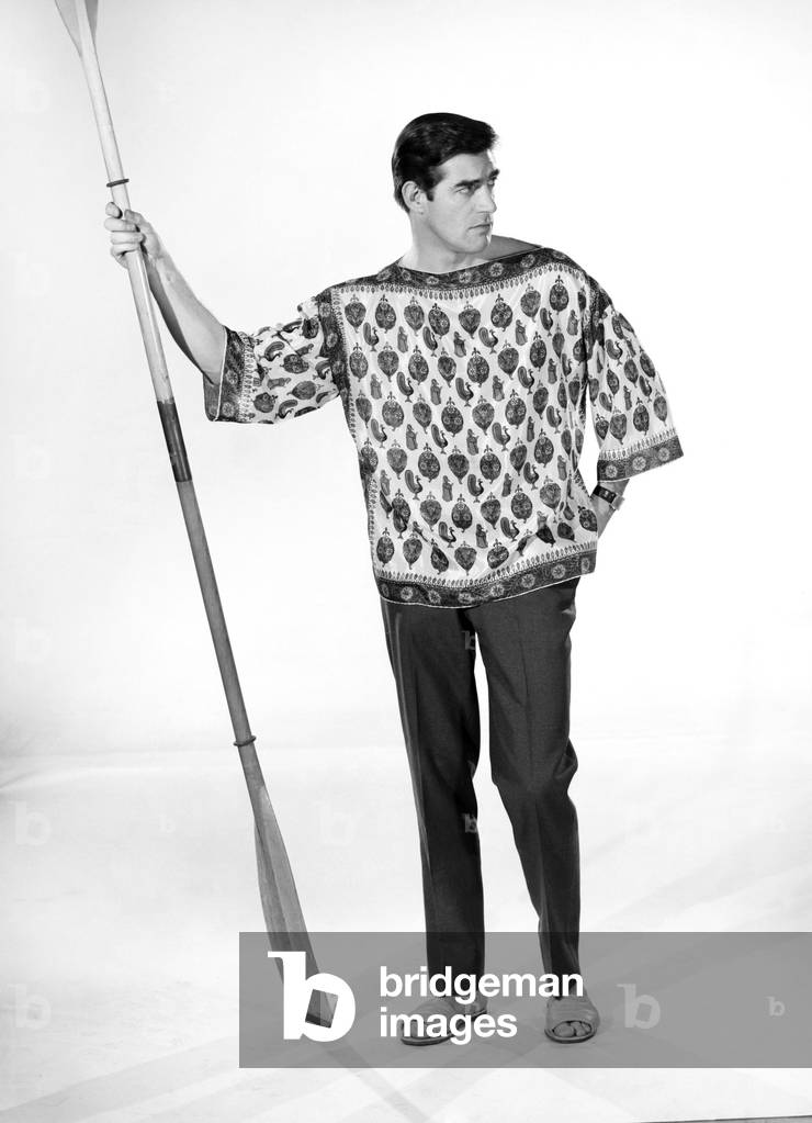Male model Peter Christian wearing silk shirt seen here holding a oar, c. 1964 (b/w photo)