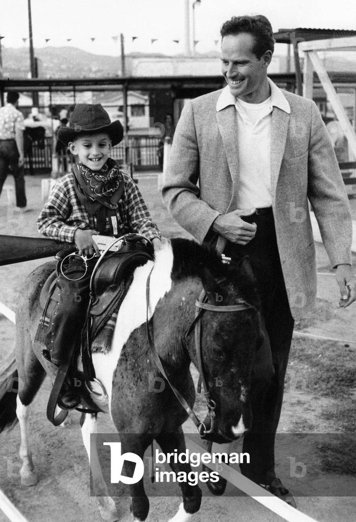 Charlton Heston with a young boy on a horse, 1960 (b/w photo)