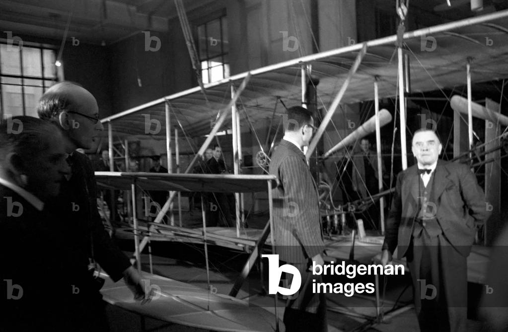 Wright Brothers 'Kitty Hawk' aeroplane, going back to U.S. from Science Museum, watched by A.V. Roe, Lord Tekenham and George Tomlinson. October 1948 O15203-006