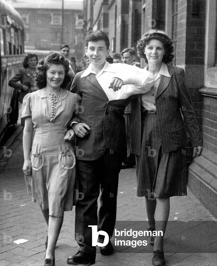 World War II Wounded: Private Paddy Clare aged 18 of the Kings Own Scottish Border Regt with 18 year old Violet Wollaston aircraft assembler (taller girl in picture) and 23 year old Vera Cherry aircraft assembler. July 1944