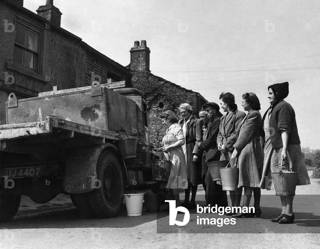 The housewives of Tottington queue up for their daily ration' of water, brought to them in a 250 gallon tank mounted on a lorry. May 1949