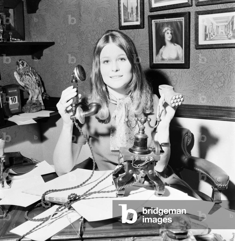 Telecommunication Exhibition at the Design Centre, Haymarket. 24 year old Pamela Houghton with a cordless telephone of the 1890's, (right), and introduced in the 1890's the first hand micro-telephone type. A magneto generator was used for calling the exchange, the magneto forming the legs of the telephone. November 1969
