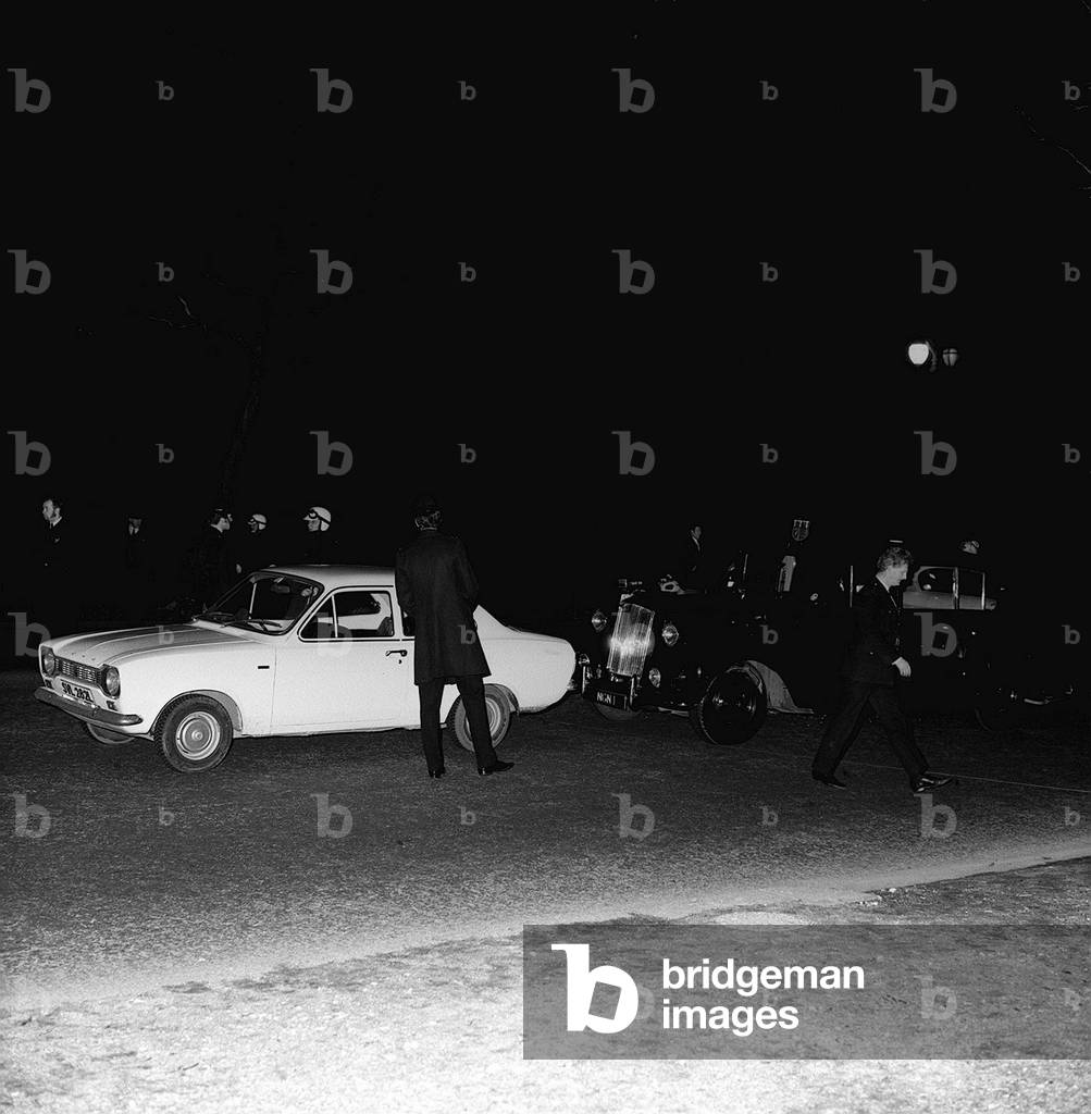 The Metropolitan Police surround the royal car and a Ford Escort after the attempted shooting of Princess Anne and Captain Mark Phillips in the Mall. The Royal car had been carrying Princess Anne and her husband Captain Mark Phillips when an armed gunman attempted to kidnap her as she drove up the Mall. T he kidnapper, Ian Ball, overtook the Princess in his Ford Escort before leaping from his car and firing six shots at the royal vehicle. One bullet somehow managed to pass between the Princess and her husband, yet neither of them were hurt. The kidnapper's plans were foiled when a royal bodyguard drew a pistol. Ball was arrested as he tried to make his escape. 20/3/74 R74/1771-9 Royals 73 Box 3 The Royal car had been carrying Princess Anne and her husband Capt. Mark Phillips when an armed gunman attempted to kidnap the Princess as she drove up the Mall. The kidnapper, a one Ian Ball overtook the Princess in his Ford Escort before leaping from his car and firing six shots at the royal vehicle. One bullet somehow managed to pass between the Princess and her husband, yet neither of them were hurt. The kidnapper's plans were foiled when a royal bodyguard drew a pistol. Ball was arrested as he tried to make his escape. 20th March 1974 (b/w photo)