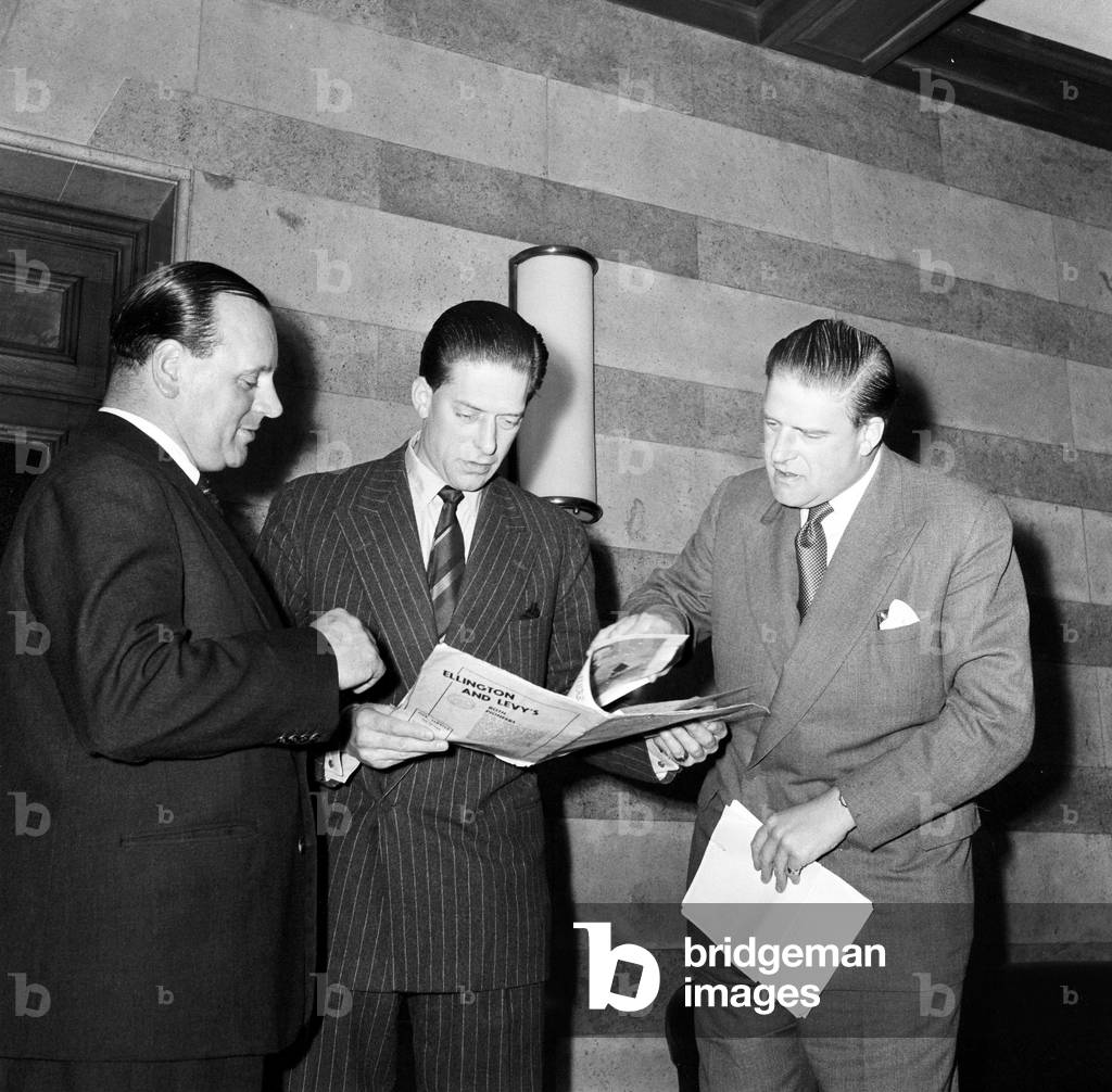 George Henry Hubert Lascelles discusses arrangements for jazz section of Leeds Music Festival 1958 with his brother Gerald Lascelles and John Addleston 1958 (b/w photo)