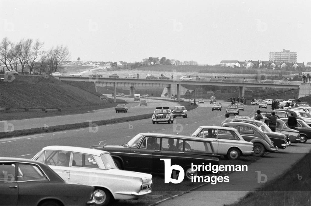 Spectators line the motorway to watch competitors in the 1970 Daily Mirrors World Cup Rally. No 3 Peter Jopp B.L.M.C. 1800 is seen here making its way from start of the at Wembley to Dover , April 19th 1970