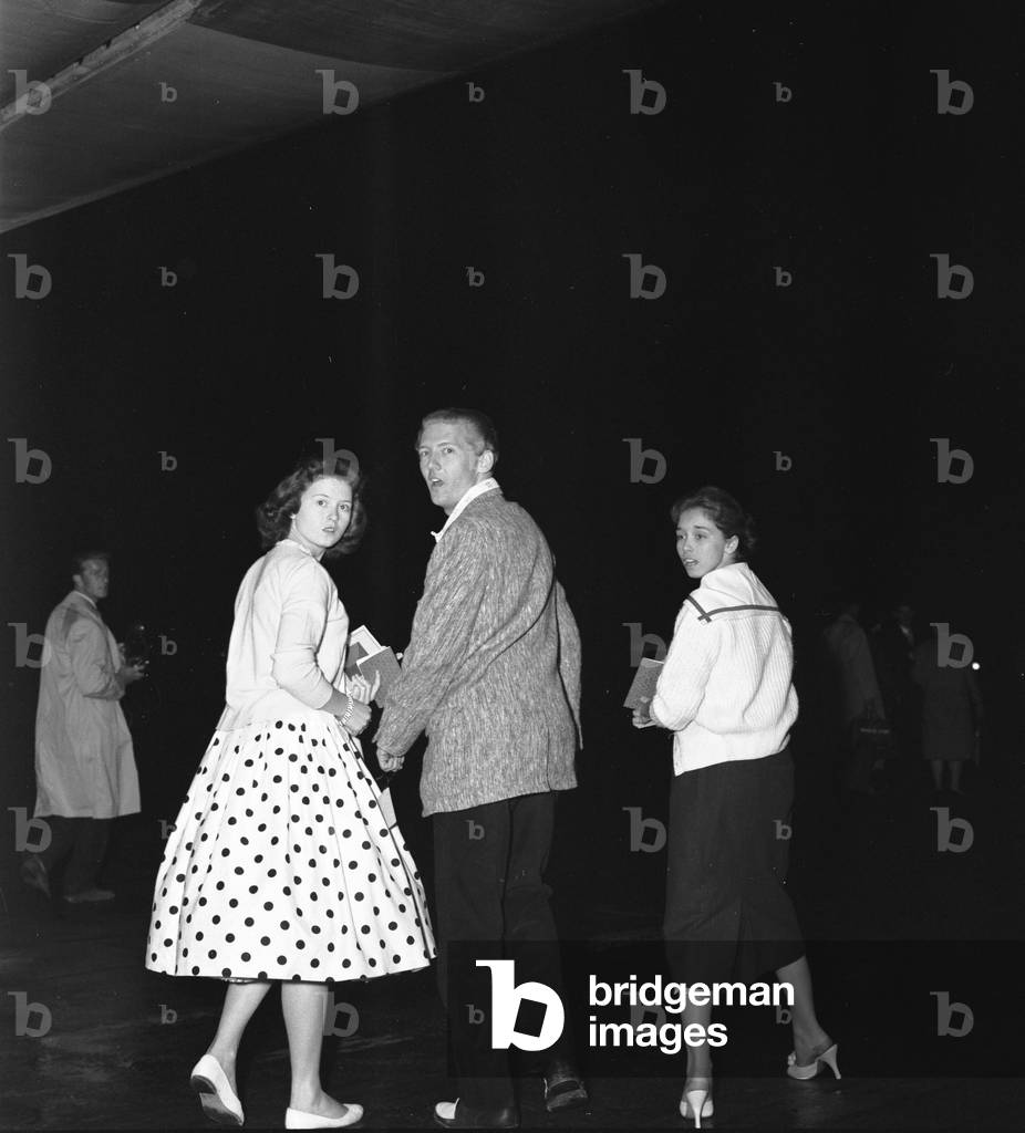American rock and roll singer Jerry Lee Lewis with his thirteen year old wife Myra (right) and his sister Jean walking to their plane at London airport on their way back to the United States. 28th May 1958 (b/w photo)