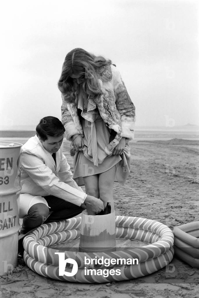 New detergent for removal of oil publicity stunt. Miss U.K. Helen Morgan demonstrates with oil on her legs, and has it removed by the detergent, March 1975 (b/w photo)