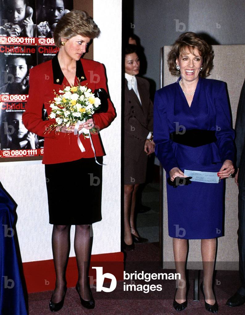 Princess Diana seen with Esther Rantzen at Childline HQ wearing red and black suit and holding a posy of flowers, January 1990 (photo)