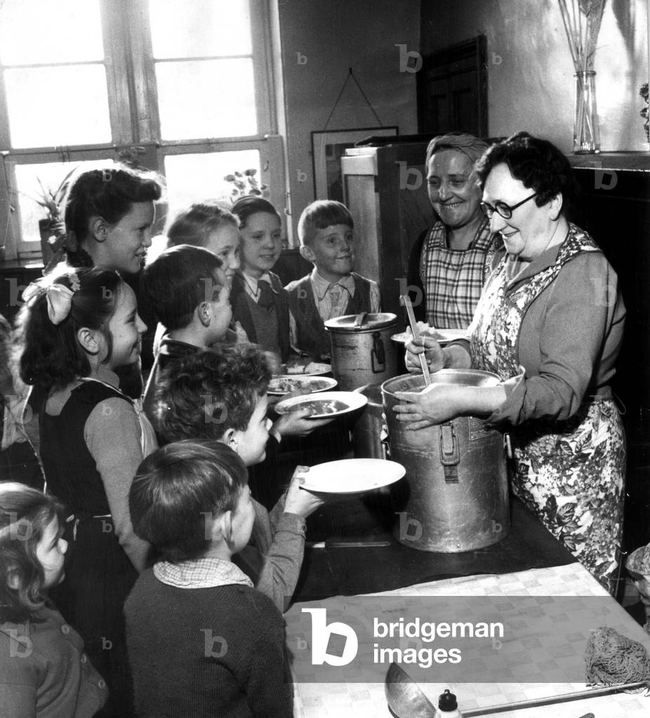 Schoolmistress Jean Cambell serving 17 children their school dinner, 1st December 1948 (b/w photo)