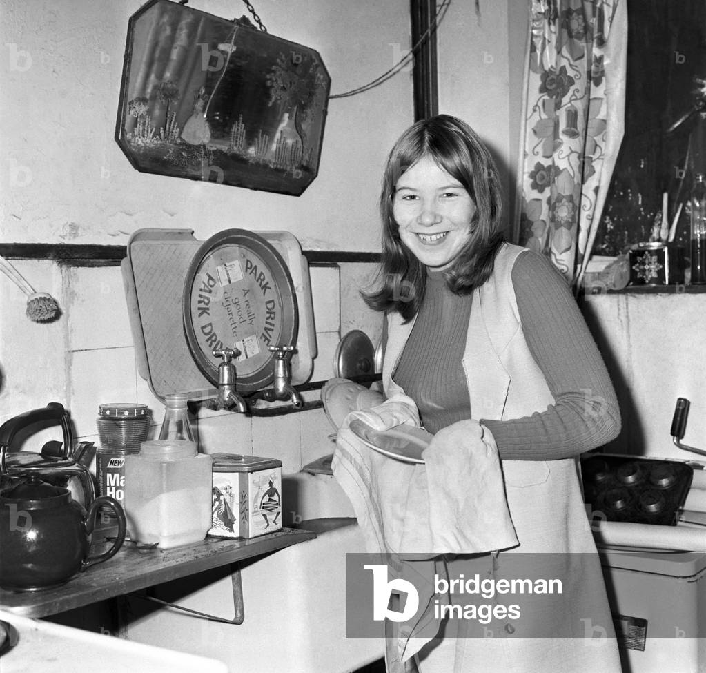 Domestic Life: Teenager Jeanette Green doing household chores at her home - here washing up in the kitchen. December 1969
