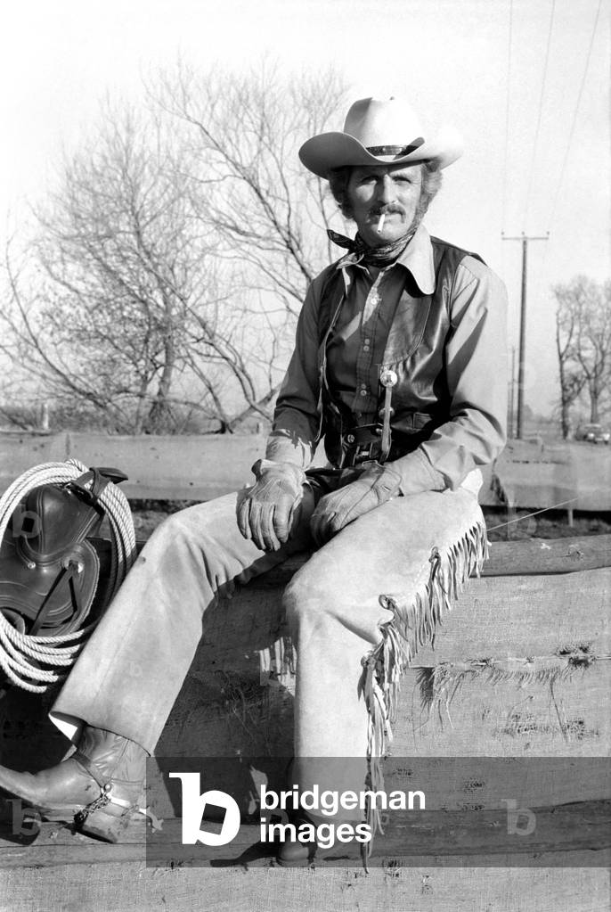 Farmer Bill Frith of Appledore, Kent, in cowboy dress and spurs, with his American Quarter horse stallion, 28th February 1975 (b/w photo)