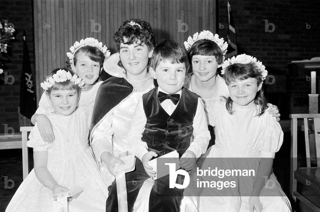 Choir girl Debbie Fox is the new Sunday school queen at St Andrew's Methodist Church, Mirfield. Debbie 16 who sings with the church's junior choir is pictured with attendants Marie Robb, Michelle Pickering, Stephanie Guck and Claire Whitehead and pageboy Joseph Pollard. 8th February 1987 (b/w photo)