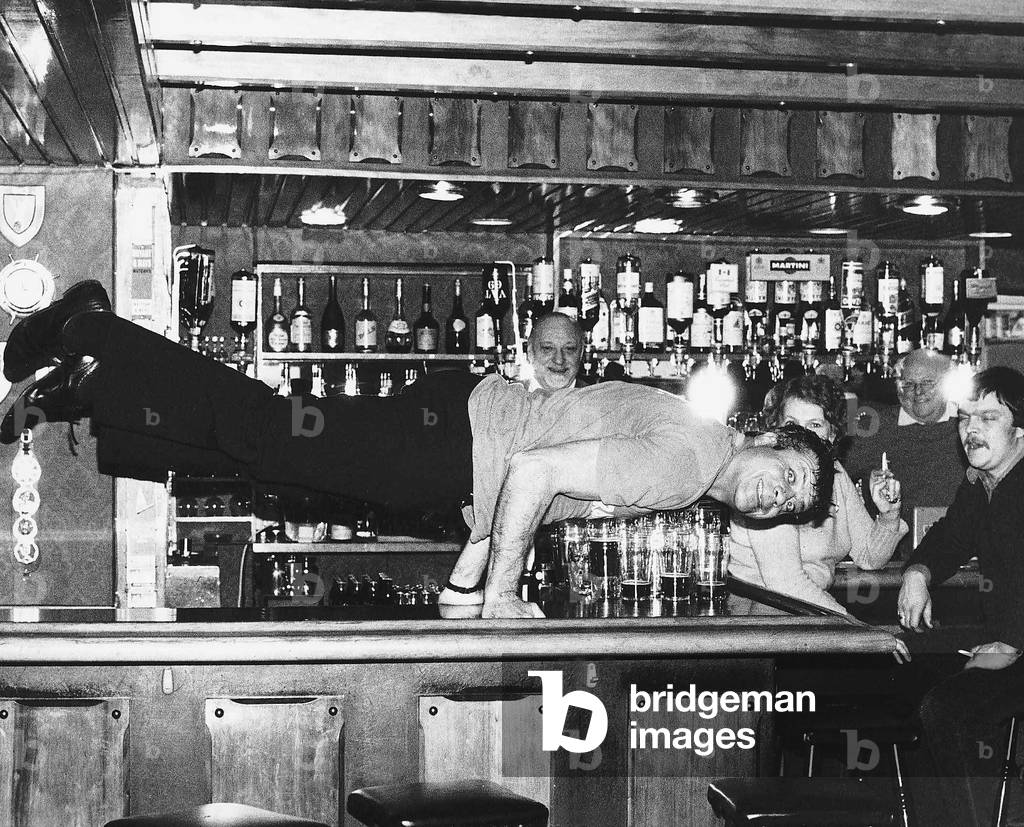 Oliver Reed actor doing press-ups on the bar at the Jamaica Inn Guernsey Currently filming Lion of the Desert, February 1979 (b/w photo)
