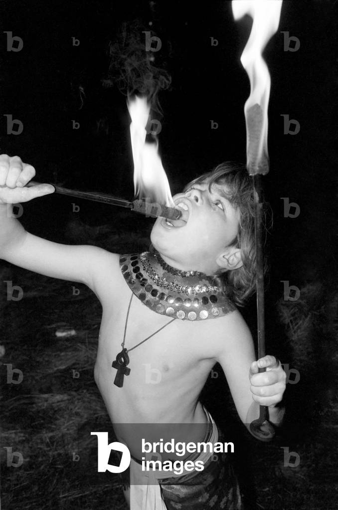 9 year old fire eater Tony Walls. Tony at his Fire Swallowing Act, December 1976 (b/w photo)