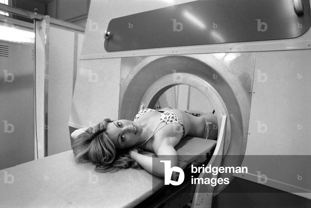 Model Gillian Duxbury in E.M.I. X-Ray scanner, April 1975 (b/w photo)