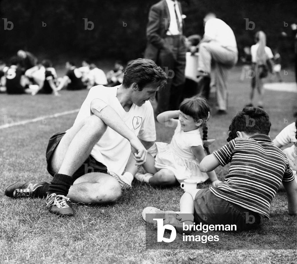Cliff Jones of Tottenham Hotspur with children during a training session at Cheshunt. 22nd August 1963 (photo)