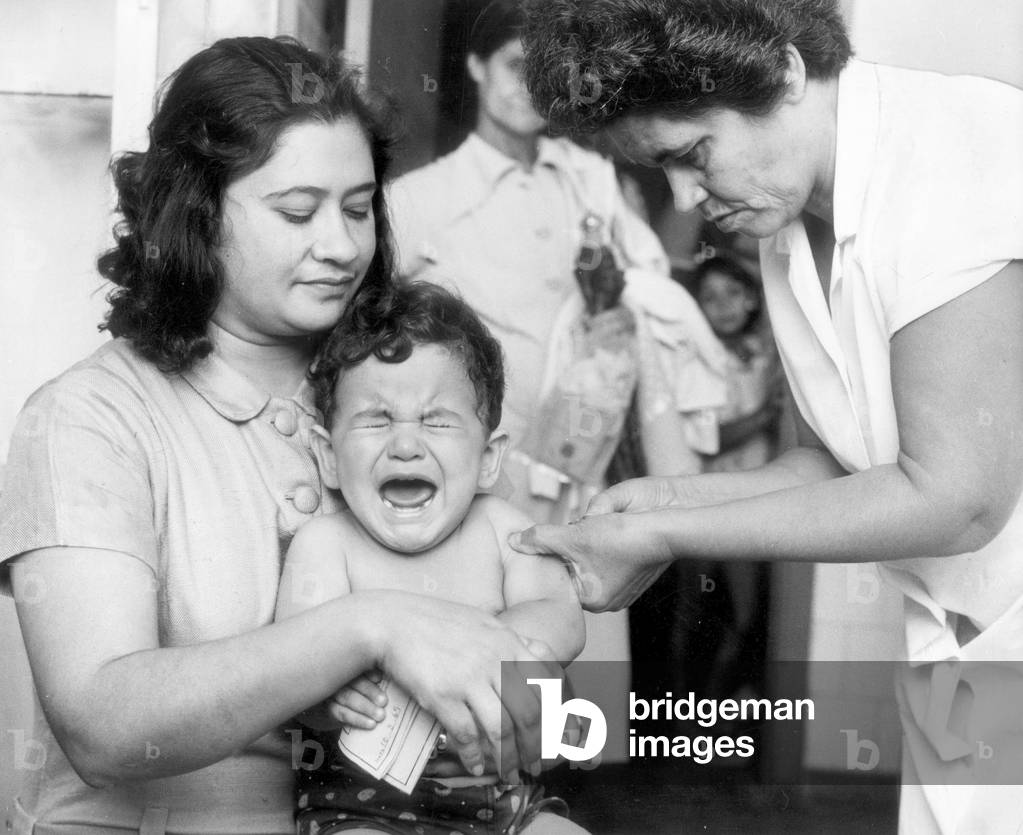 Young boy held closely by his mother, screams as the nurses gives him a vaccination against the measles. 17th March 1969 (b/w photo)