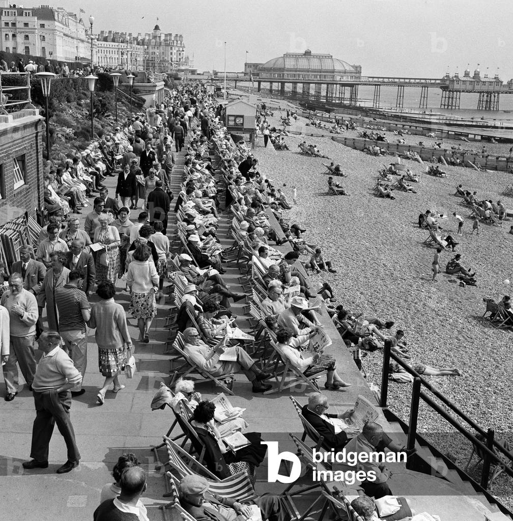 Whitsunday holiday scenes, with the pier in the background, in Eastbourne, Sussex. 10th June 1962 (b/w photo)