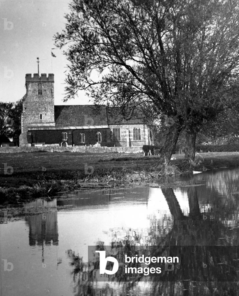 The reflection of a church in the neighbouring lake in a Kent village
 Circa 1935