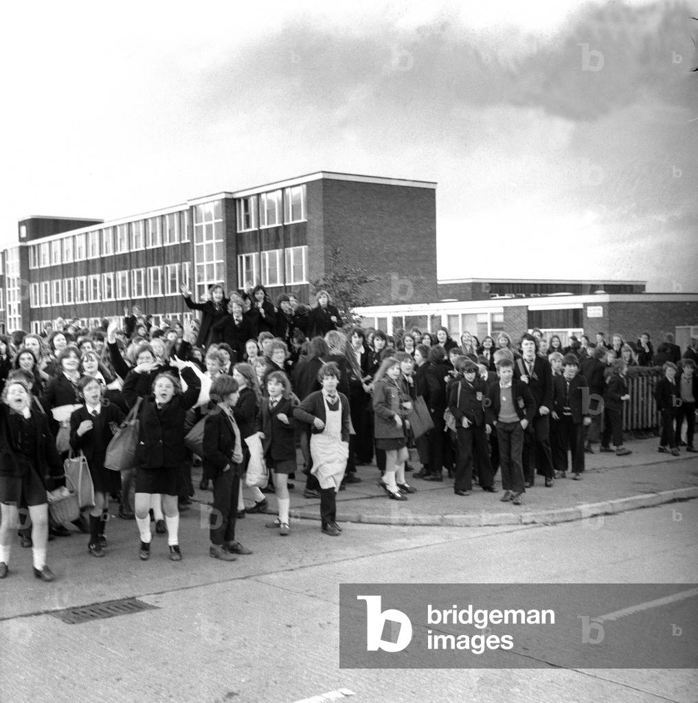 Pupils storm out of Kenton School, Newcastle, and run round the grounds chanting in protest at having to wear school uniforms, on November 11, 1974 (b/w photo)