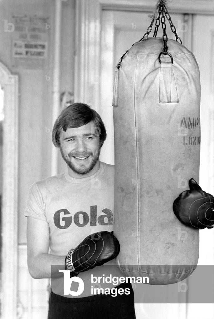 British and European Welterweight Champion John H. Stracey complete with beard at work in the 'Royal Oak' gym Canning Town, March 1975 (b/w photo)