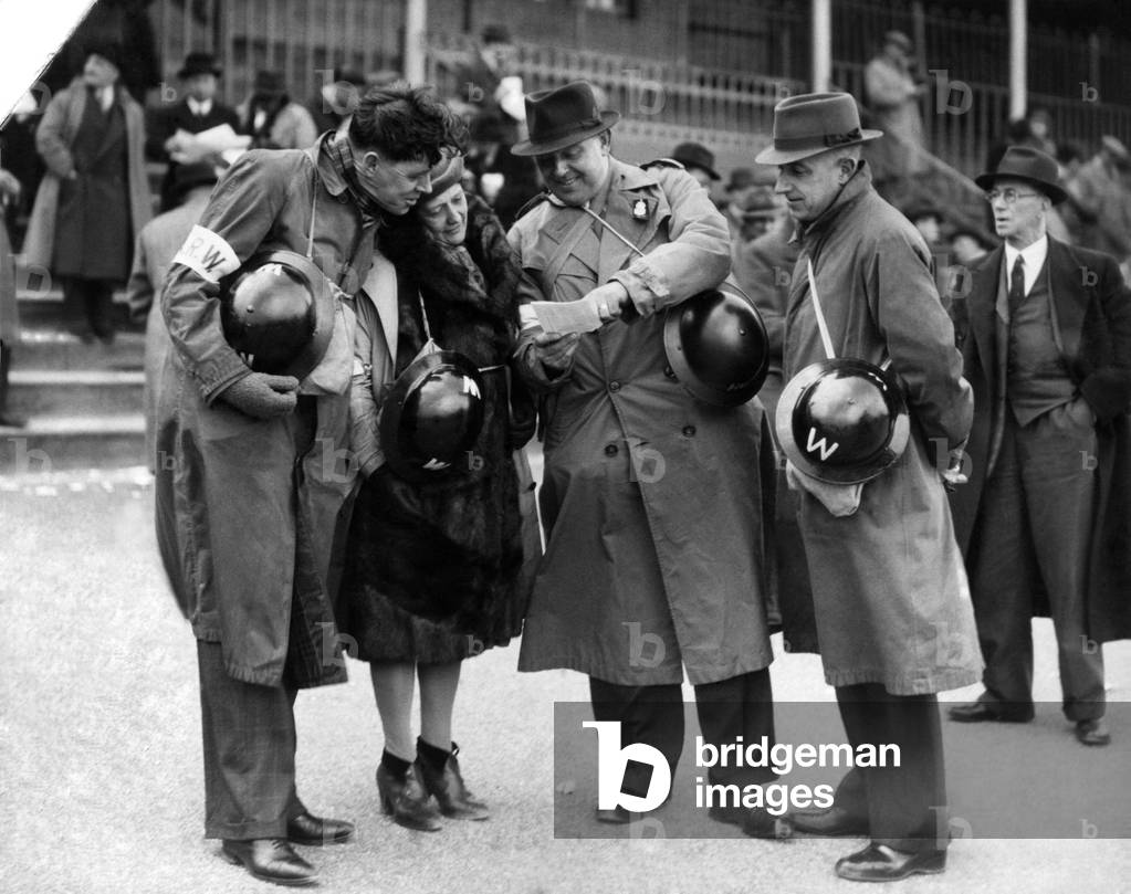 Spool Races. ARP Wardens with gas Masks and Helmets study race cards.