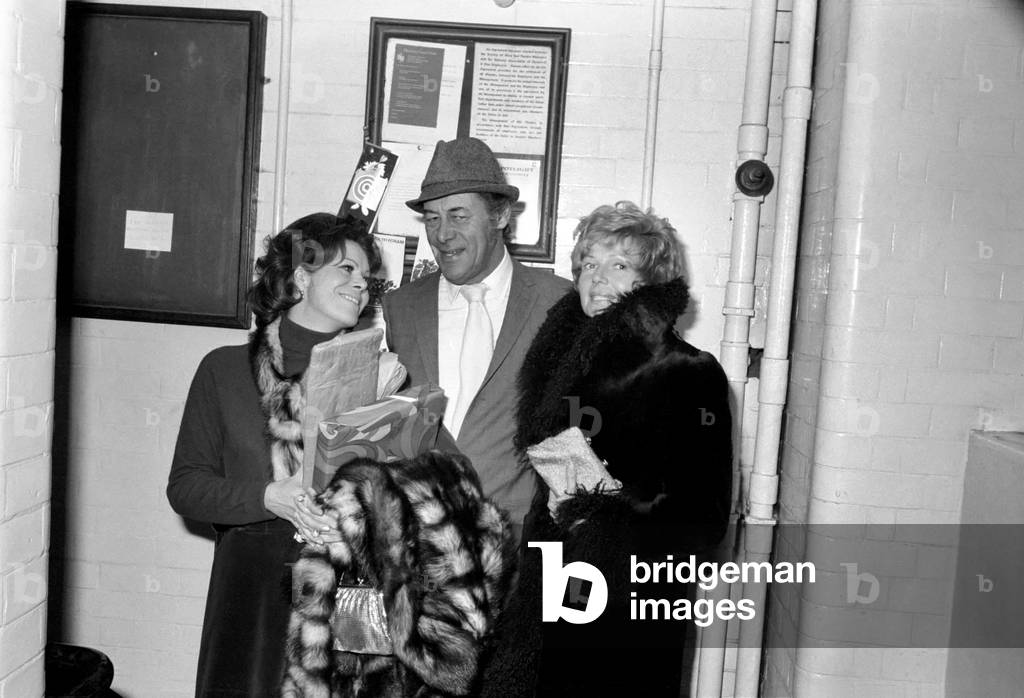 Entertainment actors Rex Harrison with his wife Rachael Roberts (left) and Rita Hayworth leaves the Lyric Theatre, Shaftesbury-avenue, London after the first night of the new stage comedy by George Hulme - 'The Lionel Touch' in which Rex Harrison plays the leading role of Lionel Fairleigh. his wife and Rita Hayworth were in the audience. November 1969